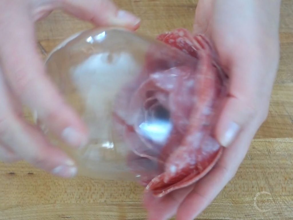 flipping the salami topped glass using both hands