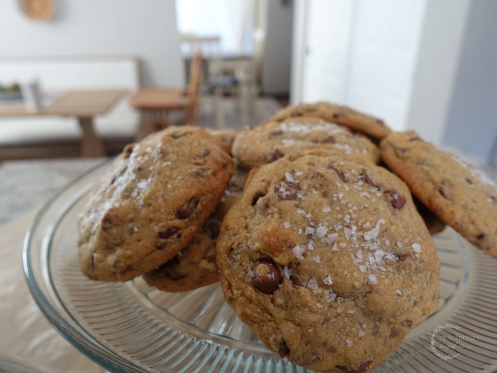 maple chocolate chip boobie biscuits on a cake stand with a high chair in the background