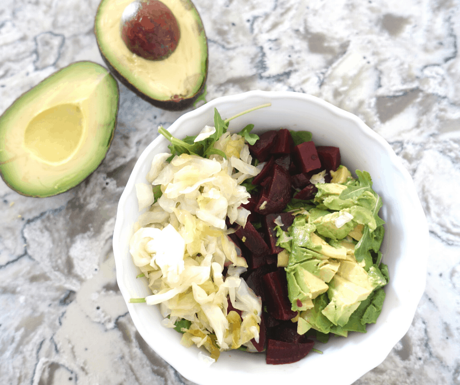 lacto fermented sauerkraut on top of a salad with beets and avocado