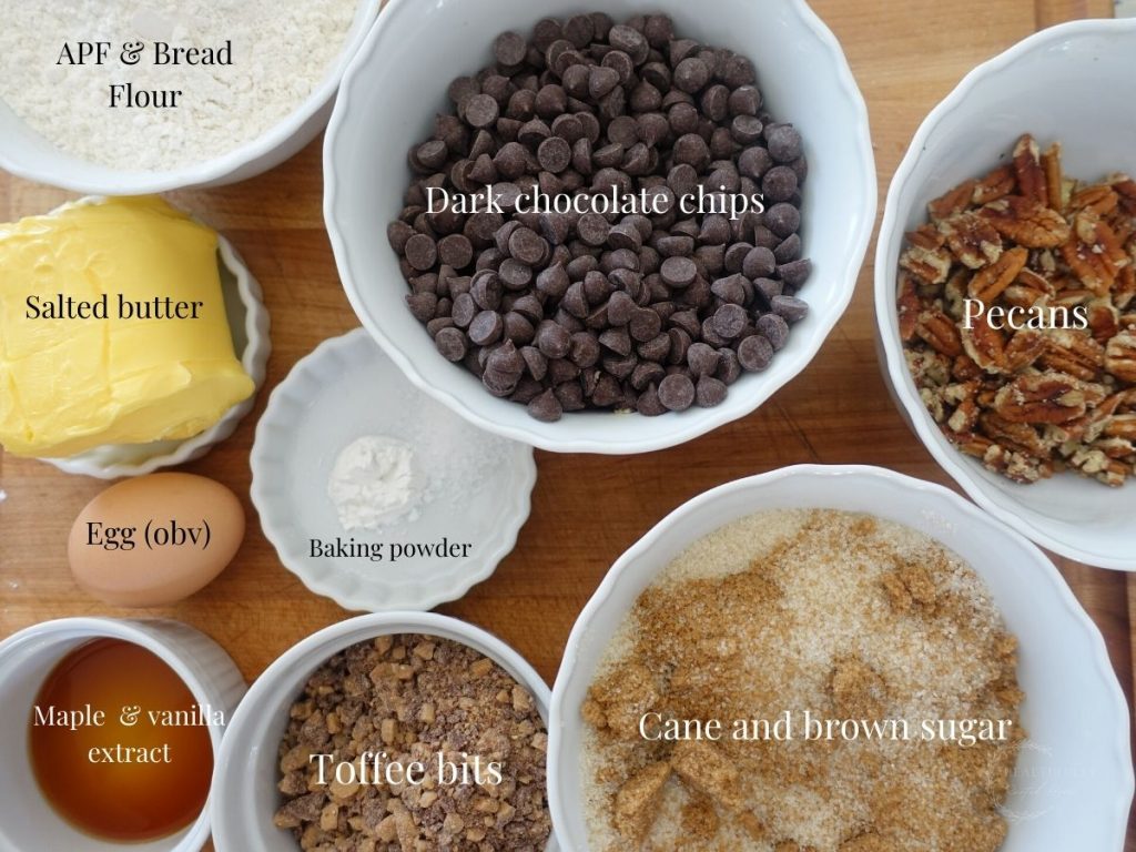ingredients in white bowls on a wooden cutting board labeled with what they are