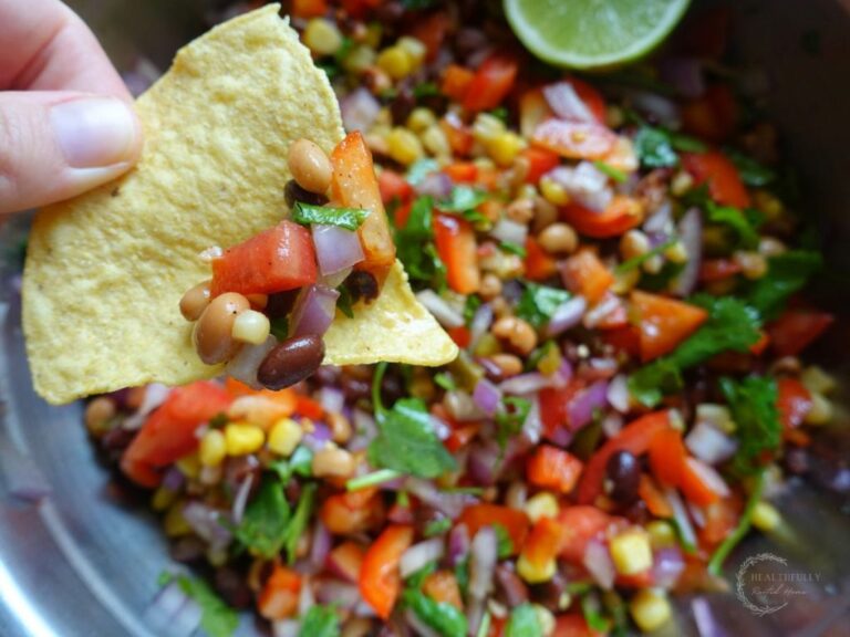 mexican caviar in a large bowl with a tortilla chip dipped inside