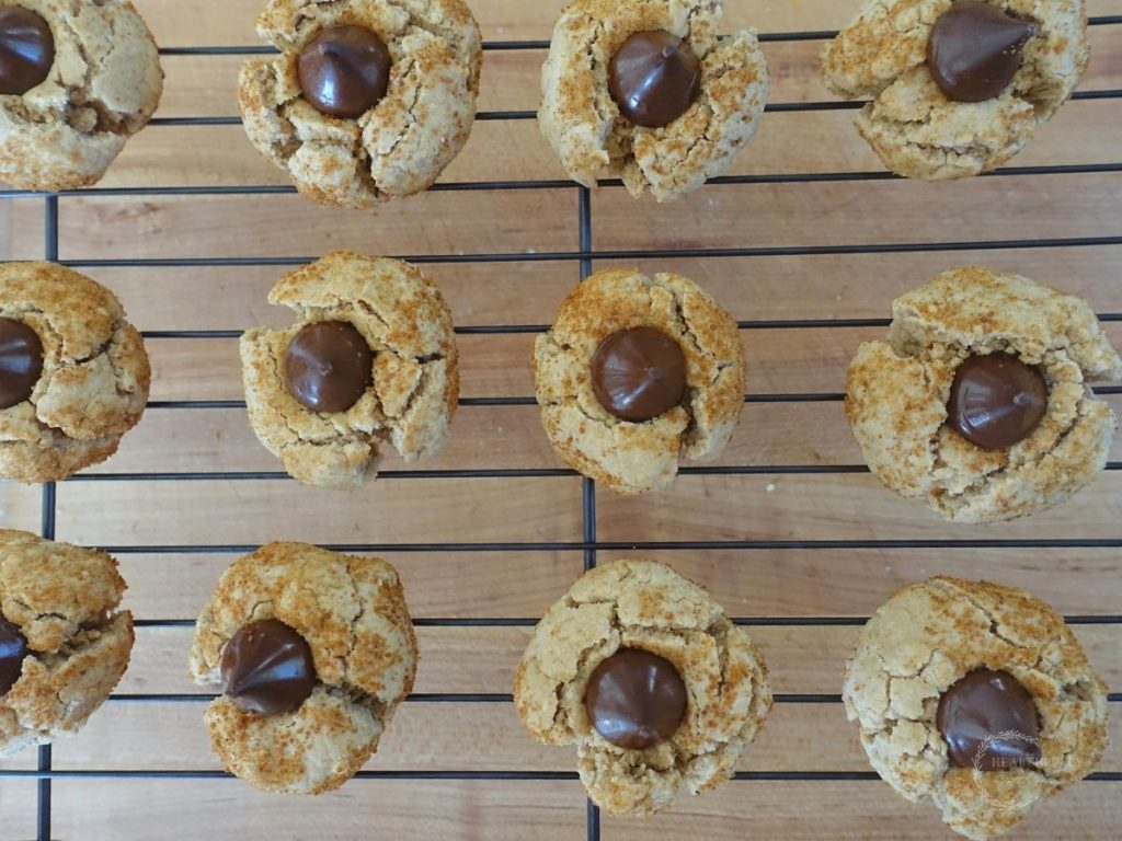 peanut kisses cooling on a wire cooling rack with a wooden cutting board underneath