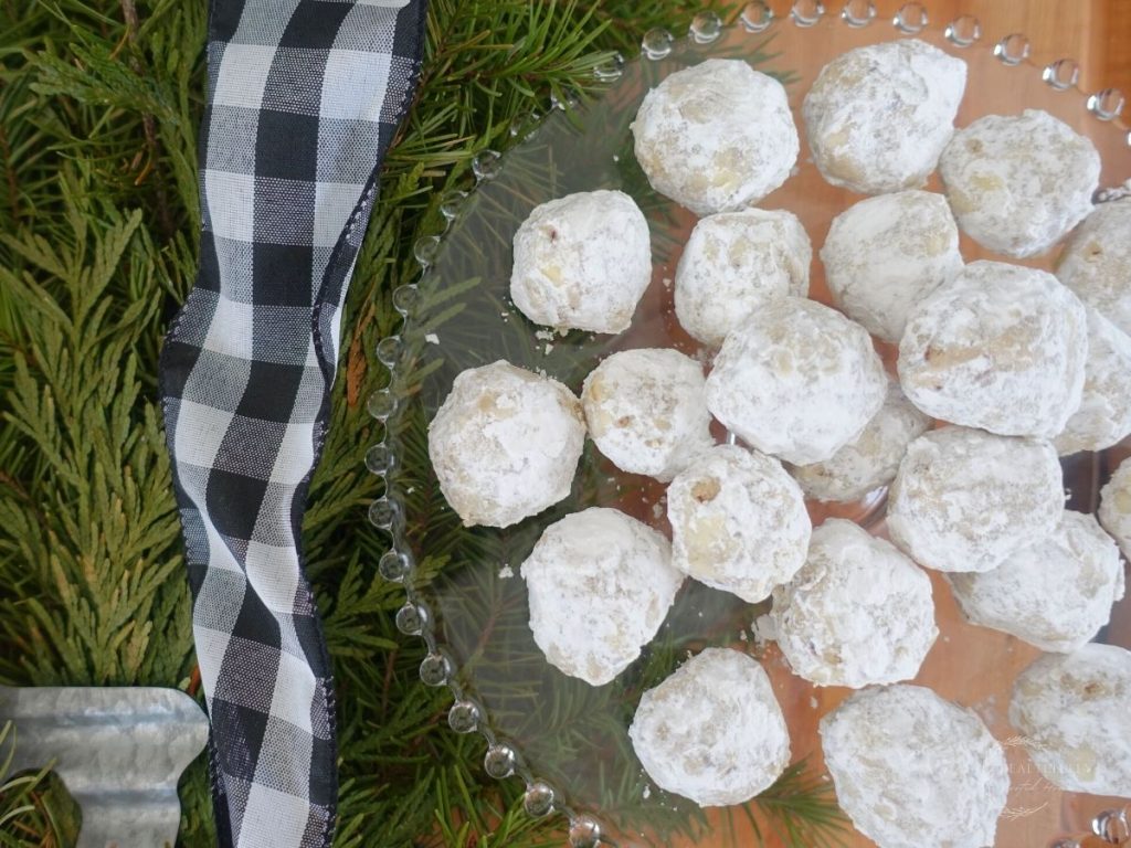 pecan meltaway cookies next to a fir tree with a black and white checkered ribbon