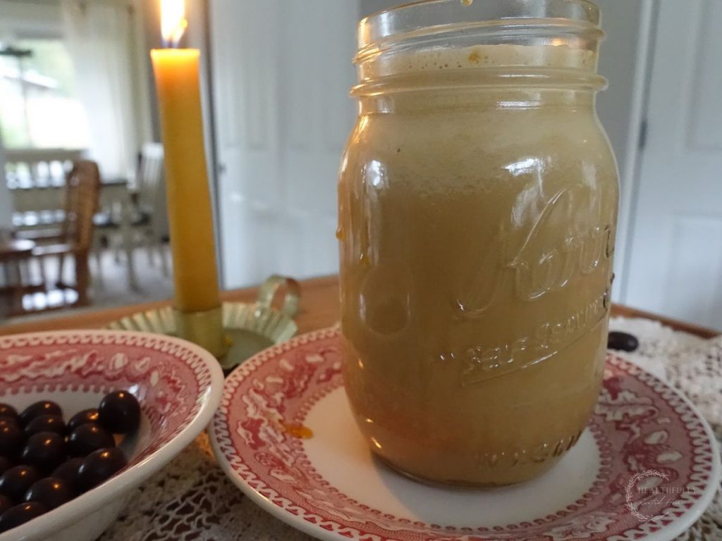 salted caramel cold foam cold brew coffee with festive red plates and chocolate covered espresso beans next to it