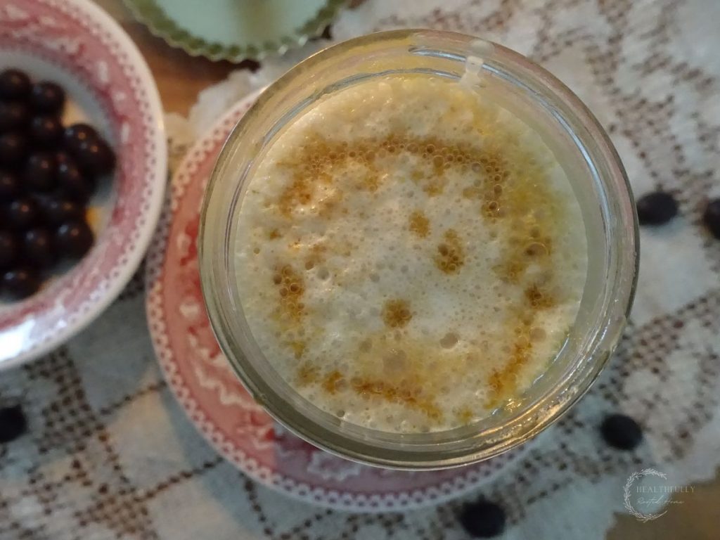 salted caramel cold foam cold brew in a mason jar with salted caramel sauce drizzled on top with festive red plates