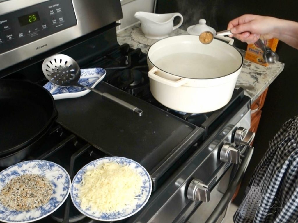adding coconut sugar to a white dutch oven of boiling water