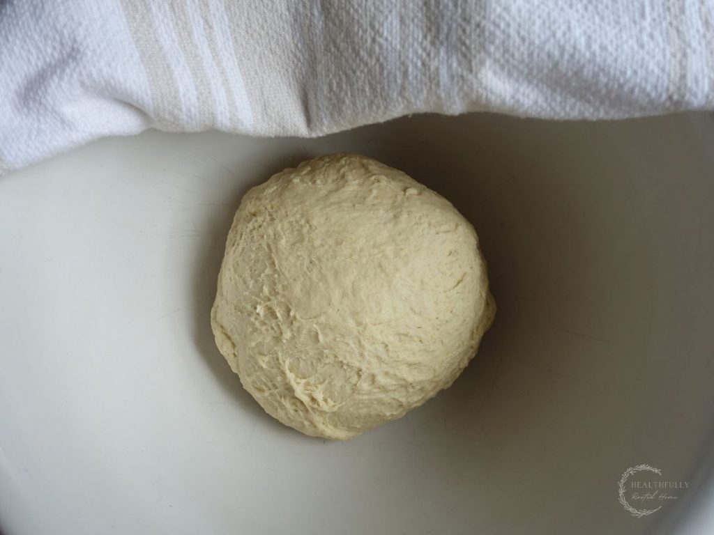 sourdough breadstick dough in a greased ceramic bowl before proofing
