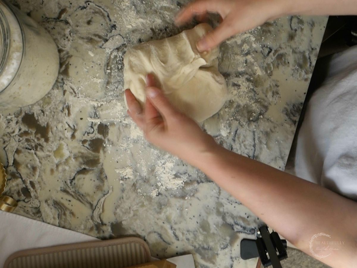 bringing one side of the sourdough discard dough to shape it