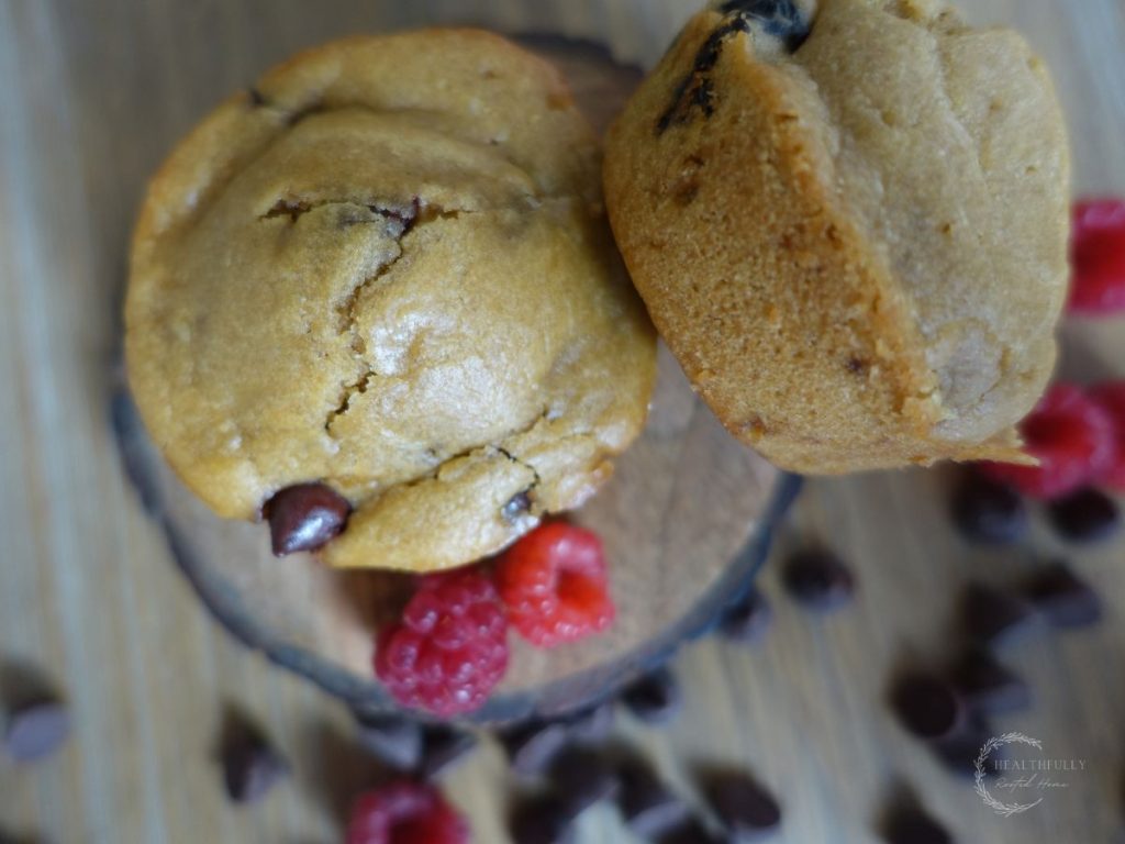raspberry chocolate sourdough discard muffins with raspberries and chocolate chips surrounding the muffins