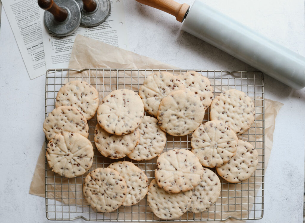 chocolate chip sugar cookies on a cooling rack with a rolling pin beside them