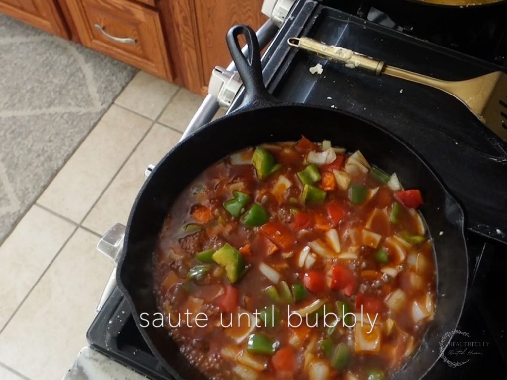 sauteing vegetales in sweet and sour sauce in a cast iron skillet