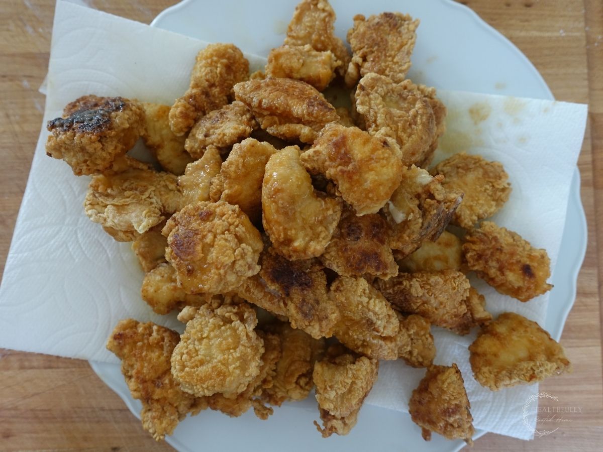 fried chicken on a paper towel lined plate resting