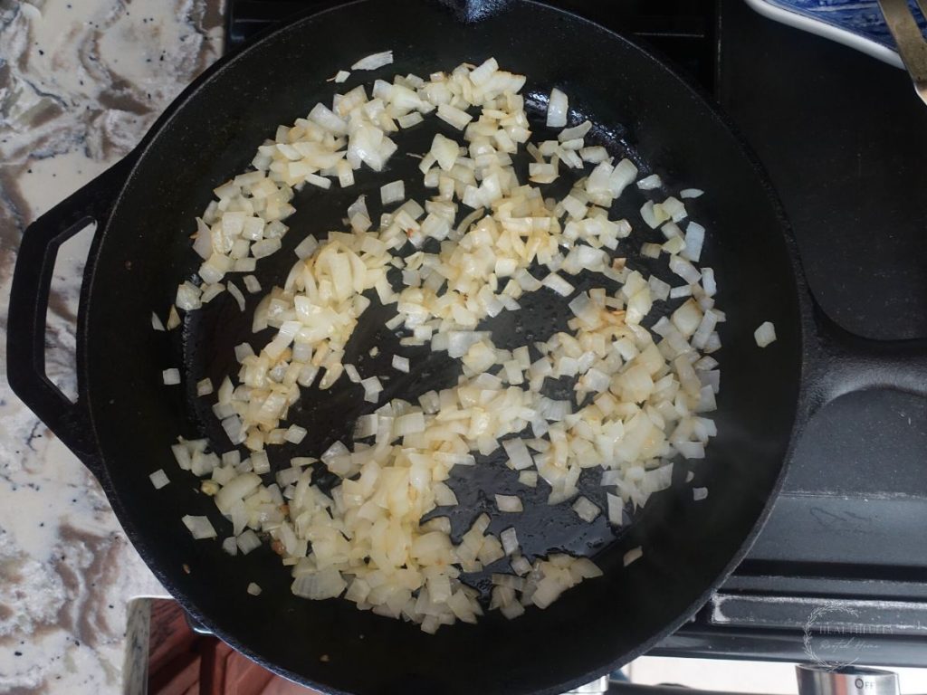 onions sautéing in a cast iron skillet to make tomato mascarpone sauce