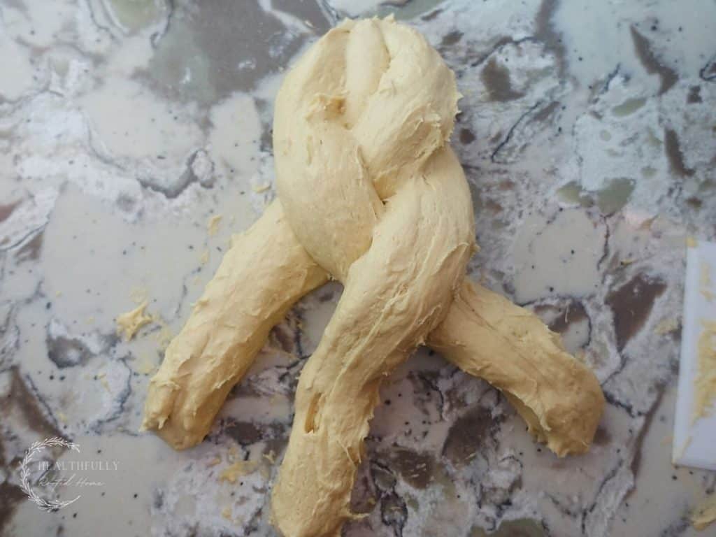 braiding dough on a granite countertop
