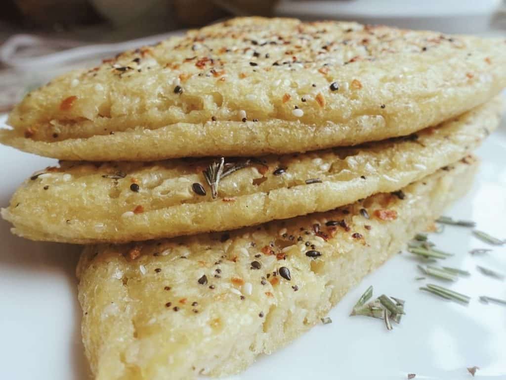 sourdough starter flatbread with everything bagel seasoning on top cut into triangles and stacked on top of eachother