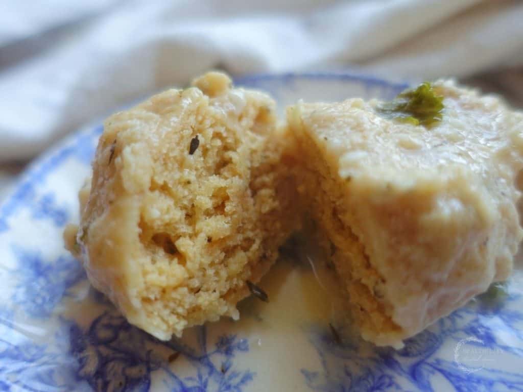 sourdough dumplings cut in half with a perfectly done inner core on a blue and white china plate