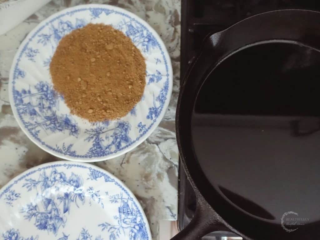 blue and white plate with cinnamon sugar next to a cast iron skillet
