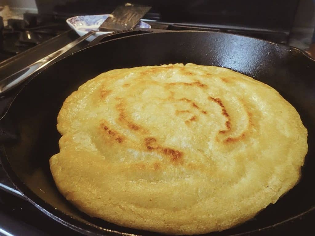 spotty brown sourdough starter flatbread in a cast iron skillet