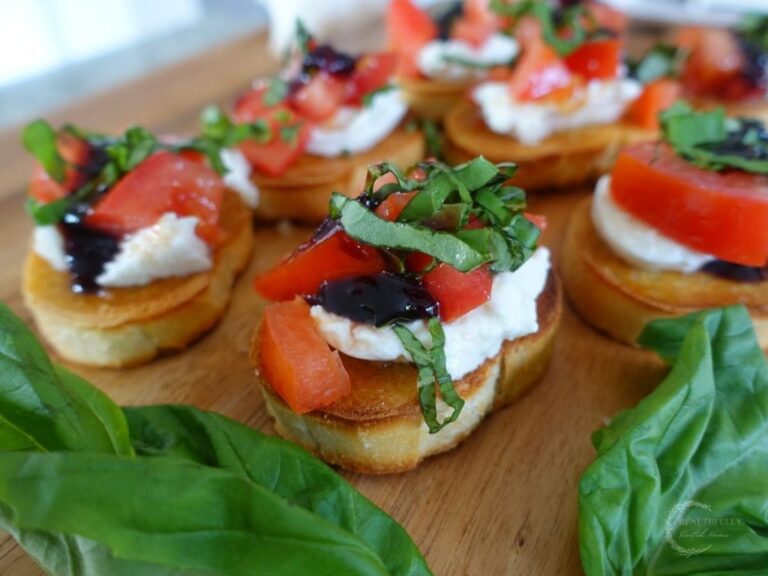 burrata bruschetta italiana on a wooden cutting board with fresh basil leaves peaking through the side
