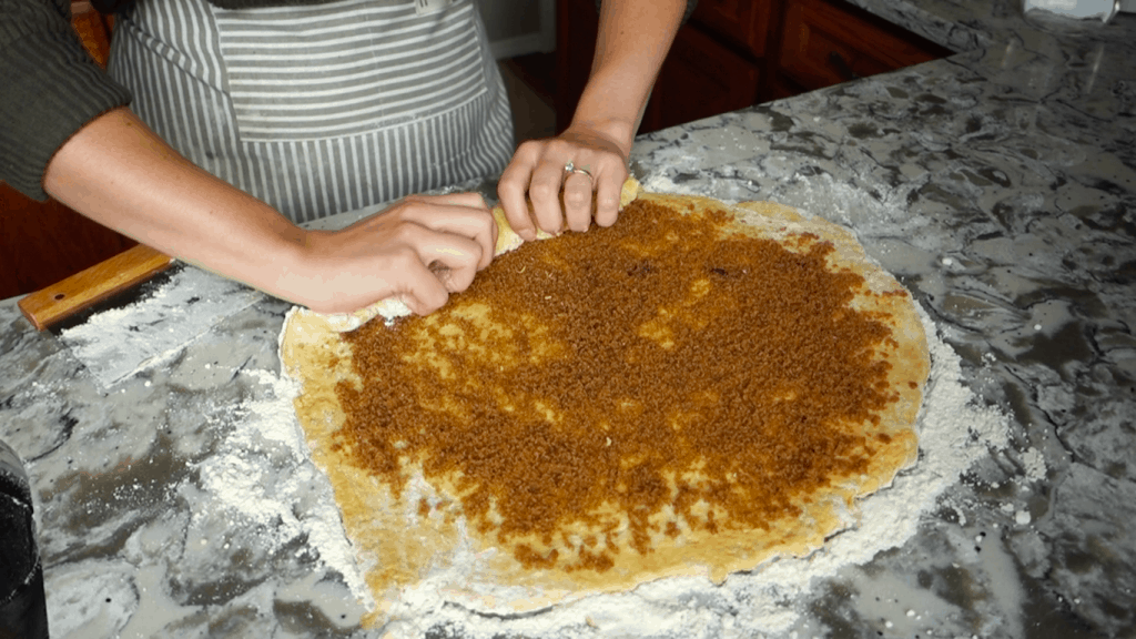 rolling pumpkin sourdough cinnamon roll dough with brown sugar filling