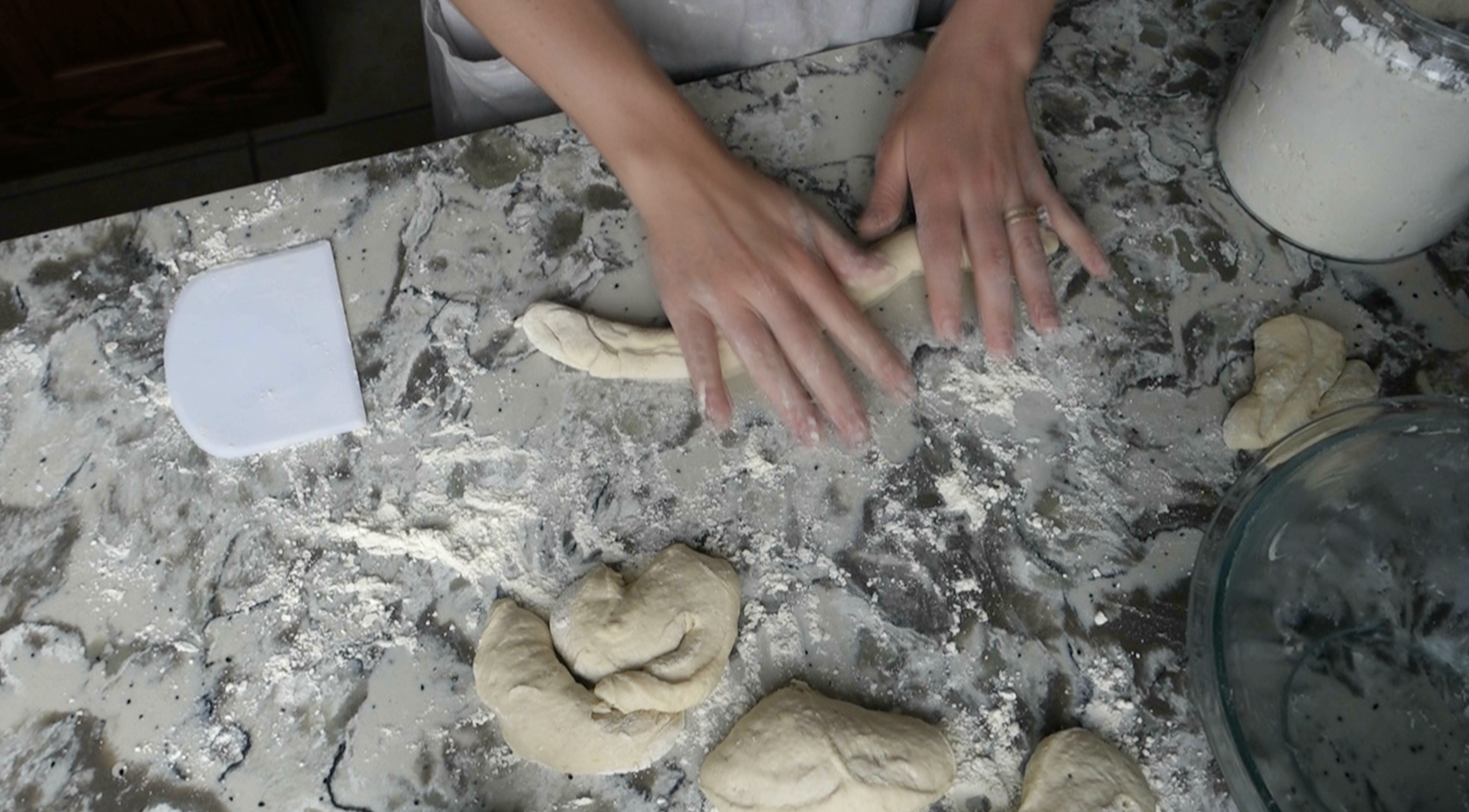 rolling out sourdough pretzel dough into a long rope