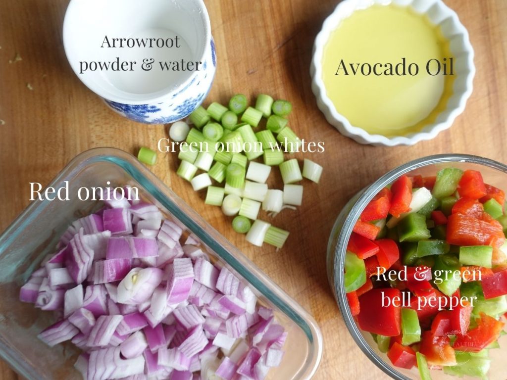 ingredients for the dish portion of chicken manchurian with bell peppers red onion oil green onions and powder slurry in jars with labels saying what they are