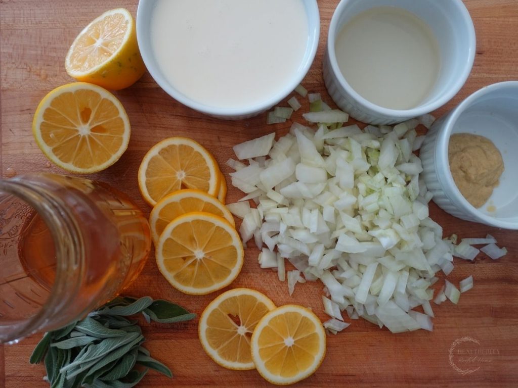 lemons onions cream dijon honey and sage on a wooden cutting board