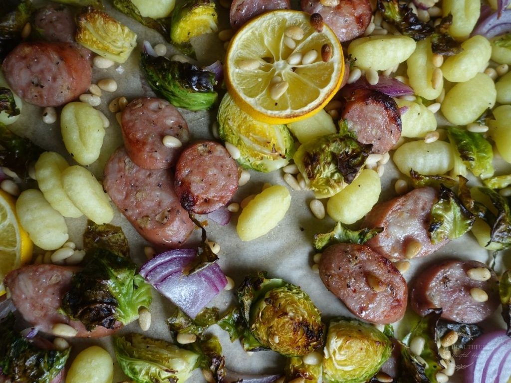 gnocchi sheet pan meal with roasted lemons vegetables gnocchi and chicken apple sausage on a baking sheet
