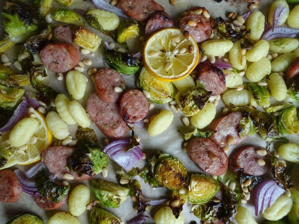 gnocchi tray bake with ingredients on a parchment lined baking sheet