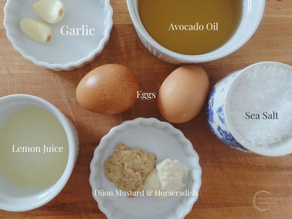 ingredients in white bowls on a wooden cutting board with labels for what they are