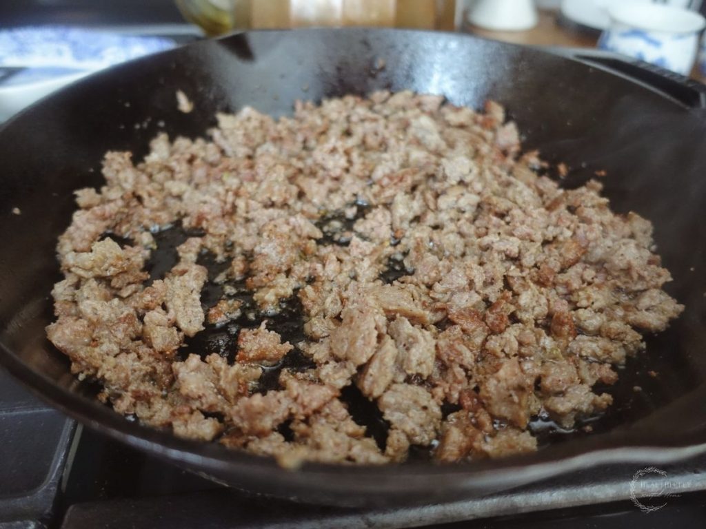 browned italian sausage in a cast iron skillet
