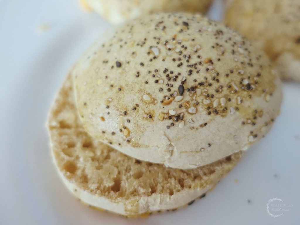 sourdough burger bun cut in half with an open crumb on a white plate