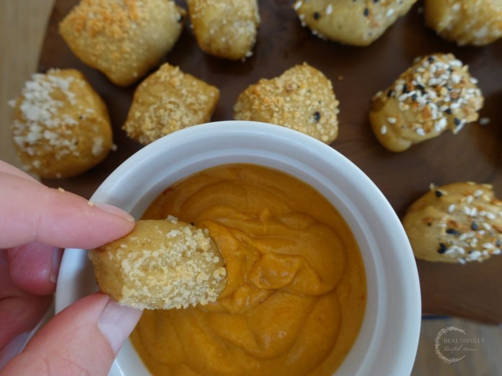 dipping sourdough pretzel bites into cheese sauce