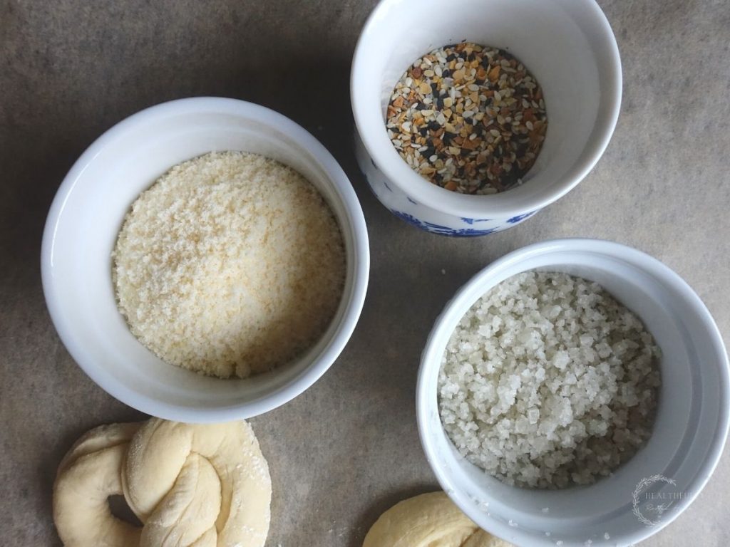 sourdough pretzel topping ideas in white jars - everything bagel seasoning parmesan cheese and sea salt