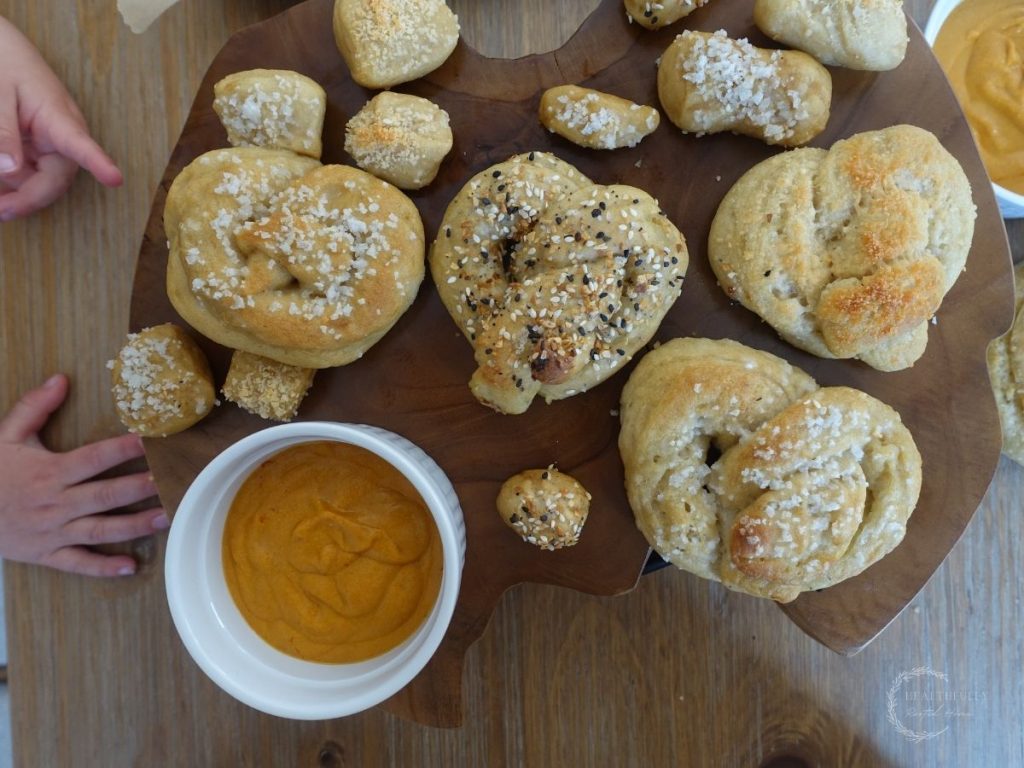 soft sourdough pretzels on a wooden block with cheese sauce