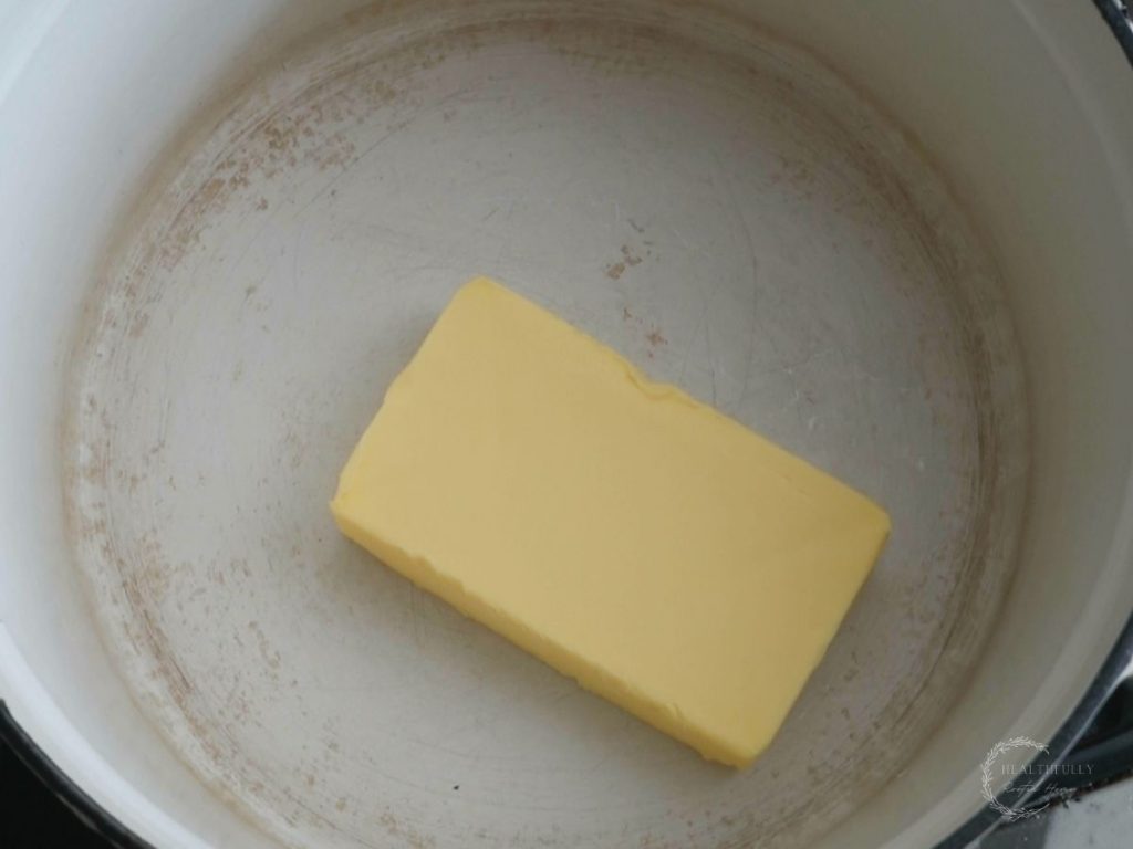 stick of butter in a white dutch oven 