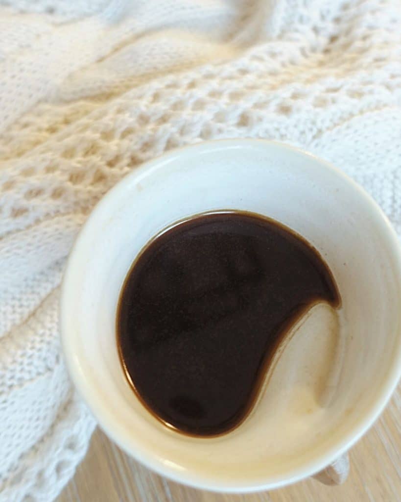 cardamom french press coffee in a clay mug with cozy sweater